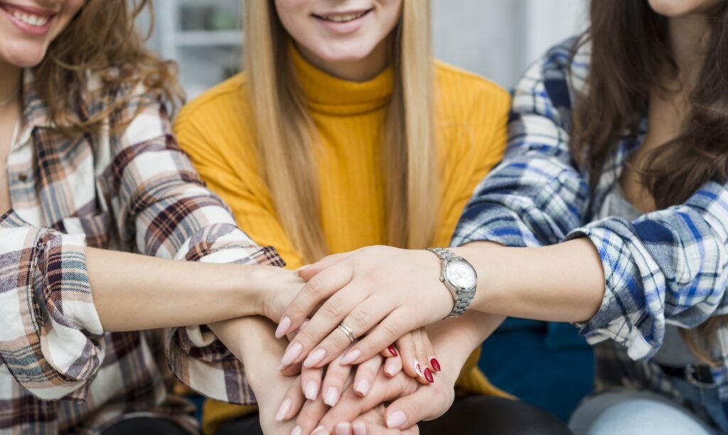 amigas con las manos juntas